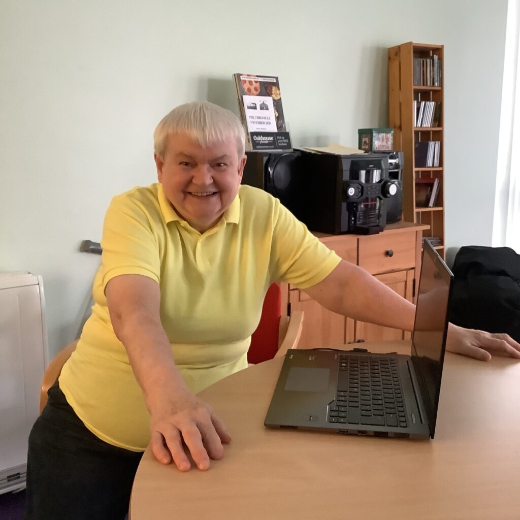 Woman with short white hair smiling with a new laptop