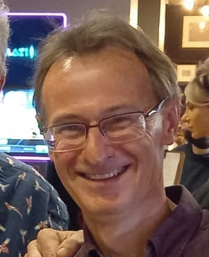 Picture of a man with glasses smiling into the camera